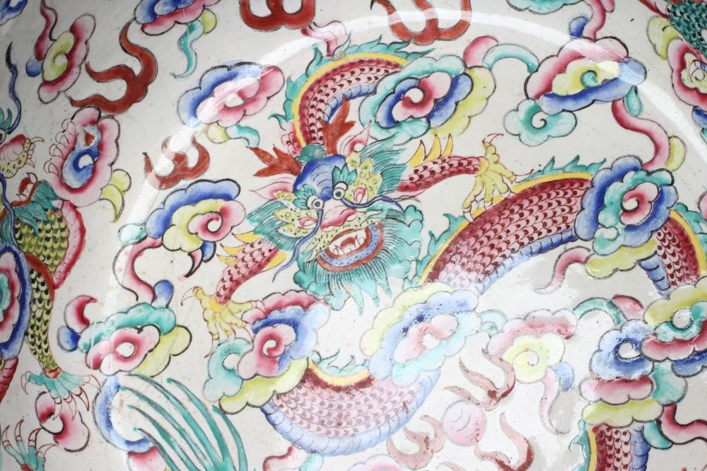 A CANTON ENAMEL BOWL of lobed circular form, painted in bright colours with dragons on a white Image