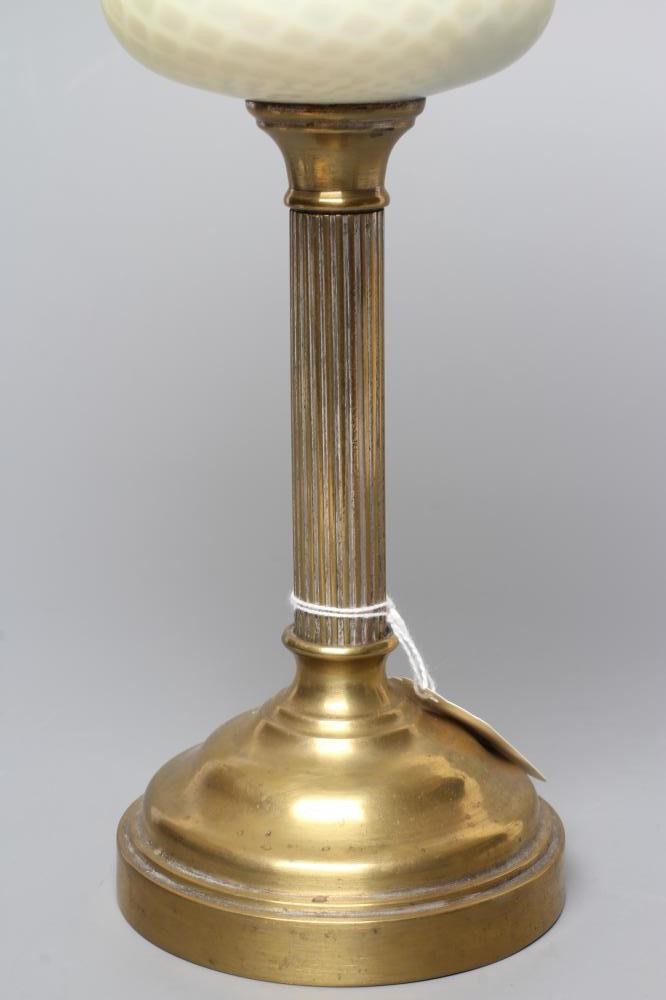 A SMALL VICTORIAN BRASS OIL LAMP, the yellow and white satin glass ball shaped shade and reservoir Image