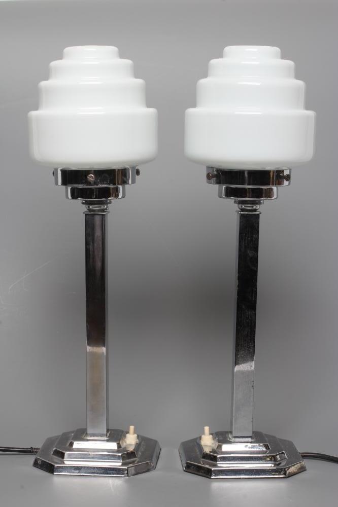 A PAIR OF ART DECO TABLE LAMPS, the stepped circular white glass shade on square chrome plated stem Image