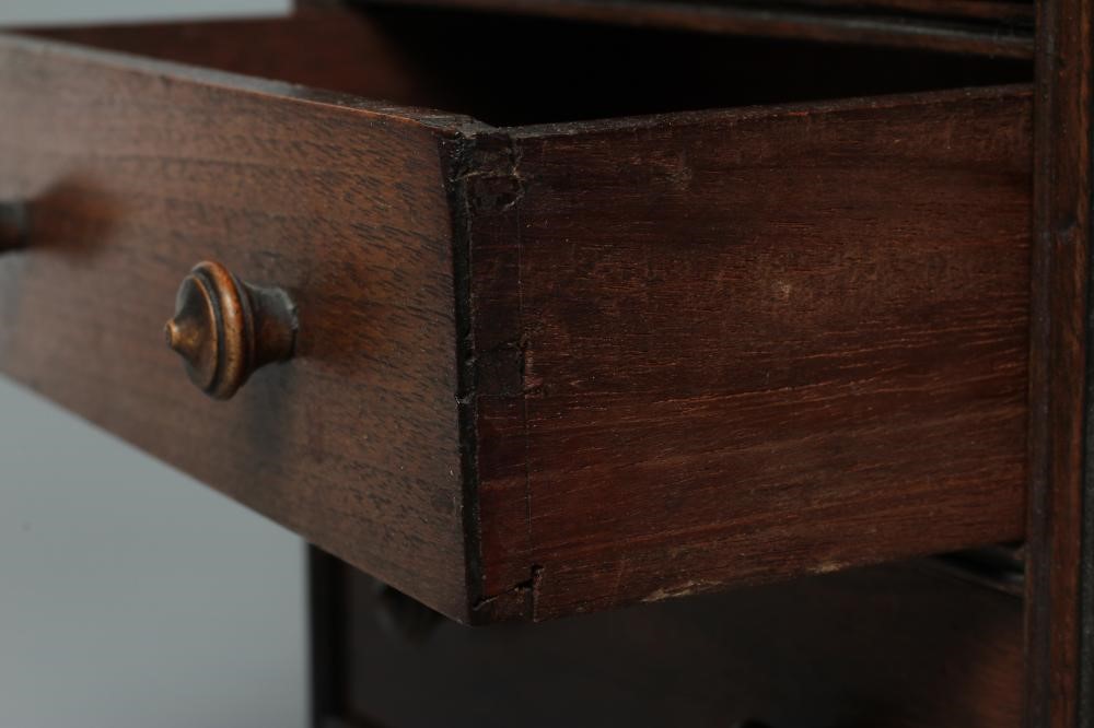 A MAHOGANY MINIATURE CHEST, early/mid 19th century, of two short over three long drawers with turned Image