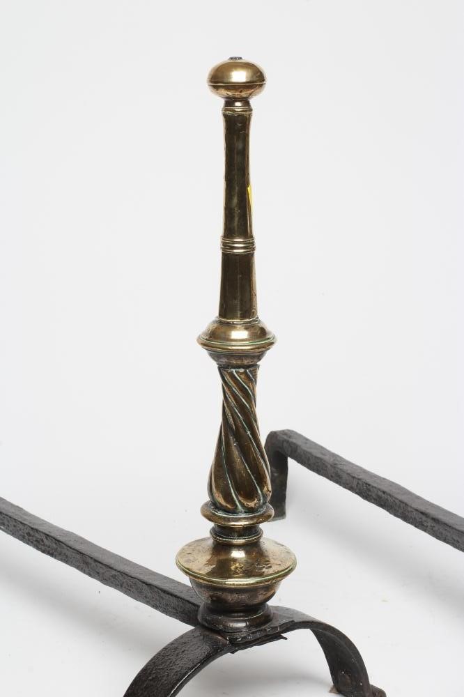 A PAIR OF ARTS AND CRAFTS WROUGHT IRON FIRE DOGS, the brass ring and wrythen turned tapering Image