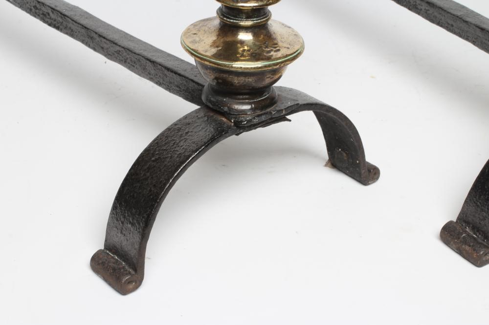 A PAIR OF ARTS AND CRAFTS WROUGHT IRON FIRE DOGS, the brass ring and wrythen turned tapering Image