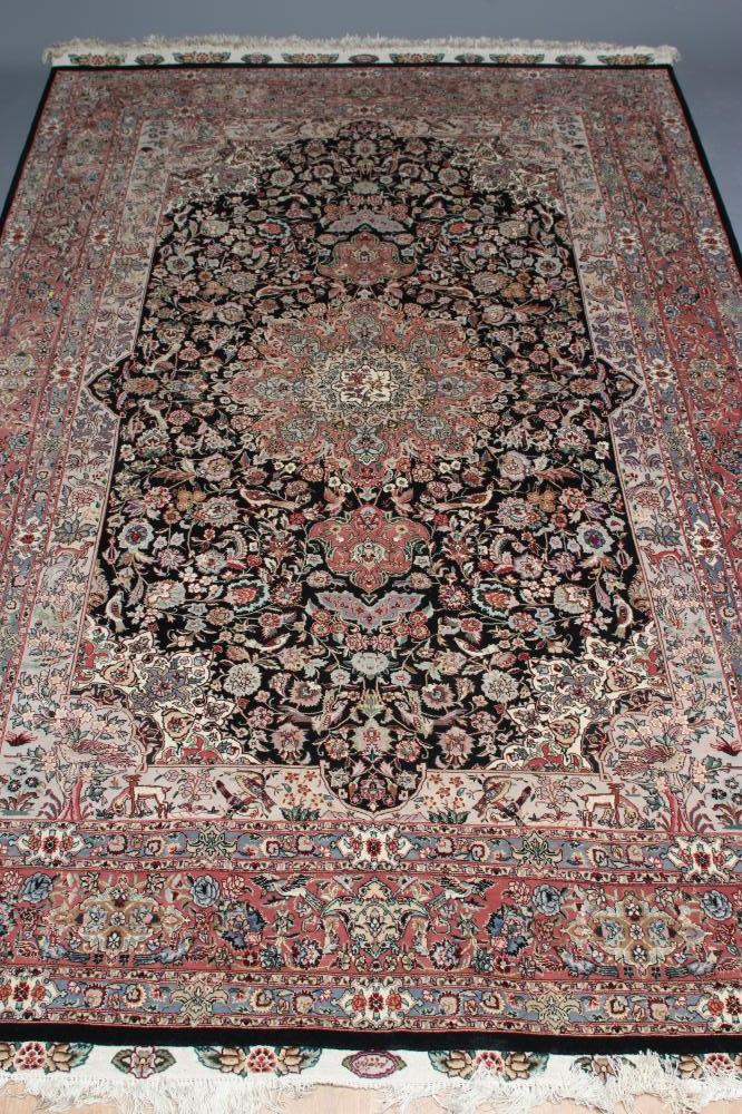 A PERSIAN RUG, the black field with rose pink gul and ivory spandrels within a pale blue border with Image