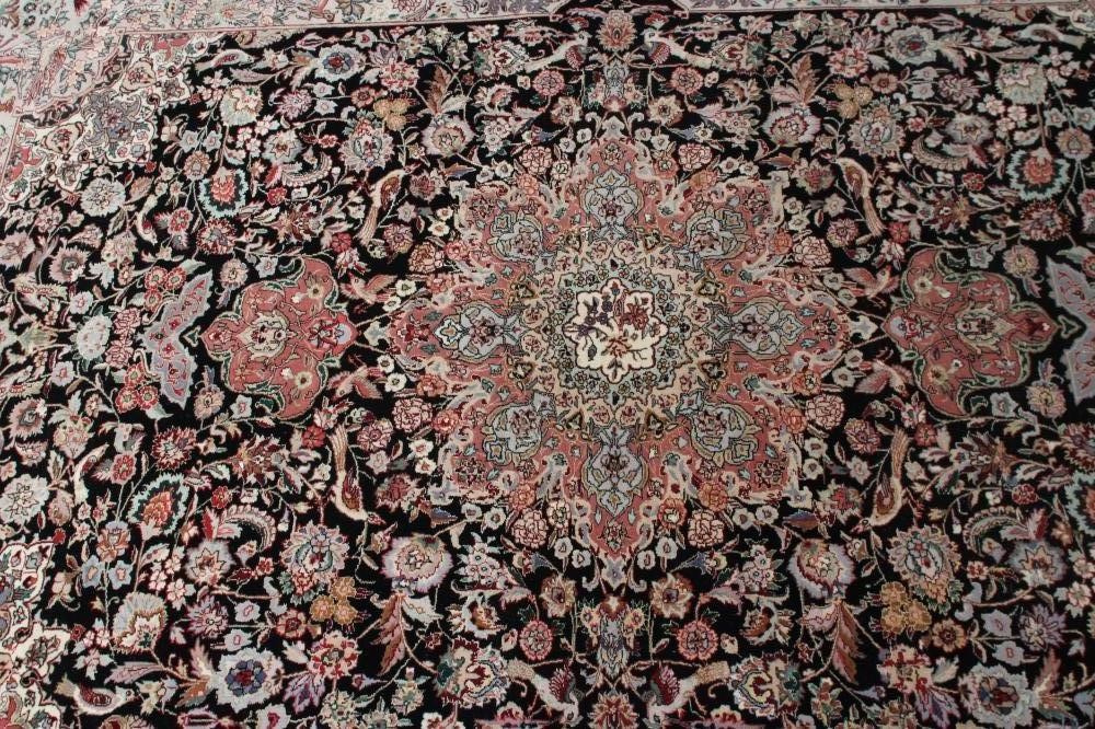 A PERSIAN RUG, the black field with rose pink gul and ivory spandrels within a pale blue border with Image