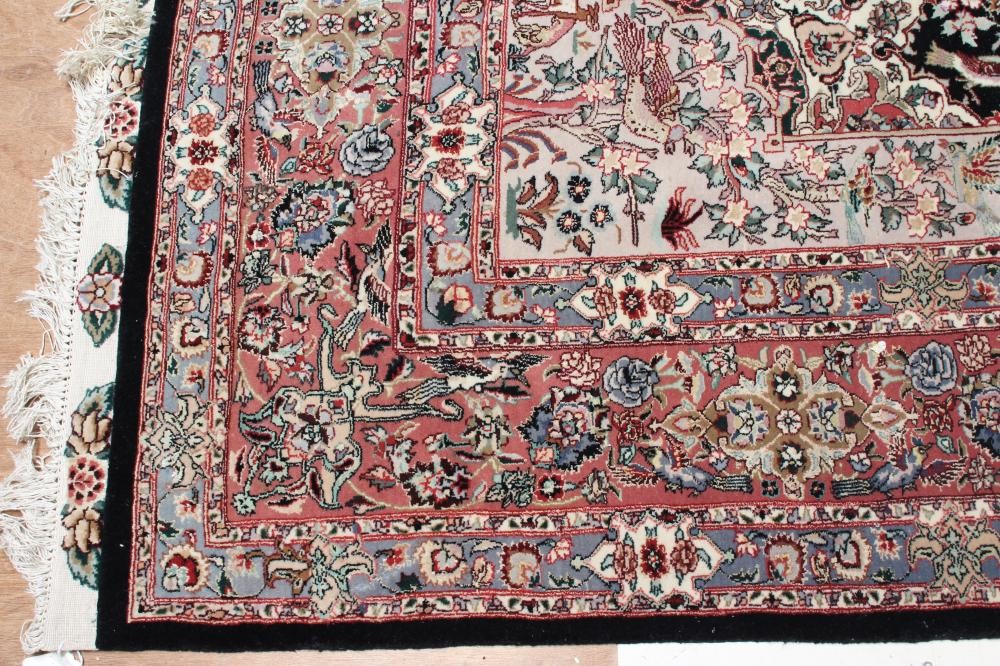 A PERSIAN RUG, the black field with rose pink gul and ivory spandrels within a pale blue border with Image