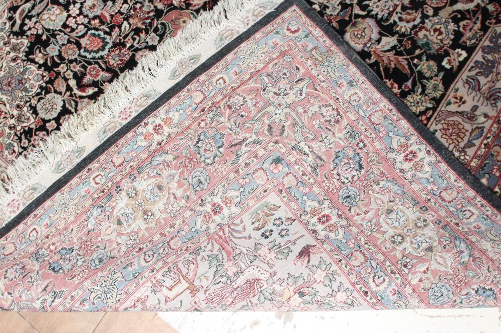 A PERSIAN RUG, the black field with rose pink gul and ivory spandrels within a pale blue border with Image