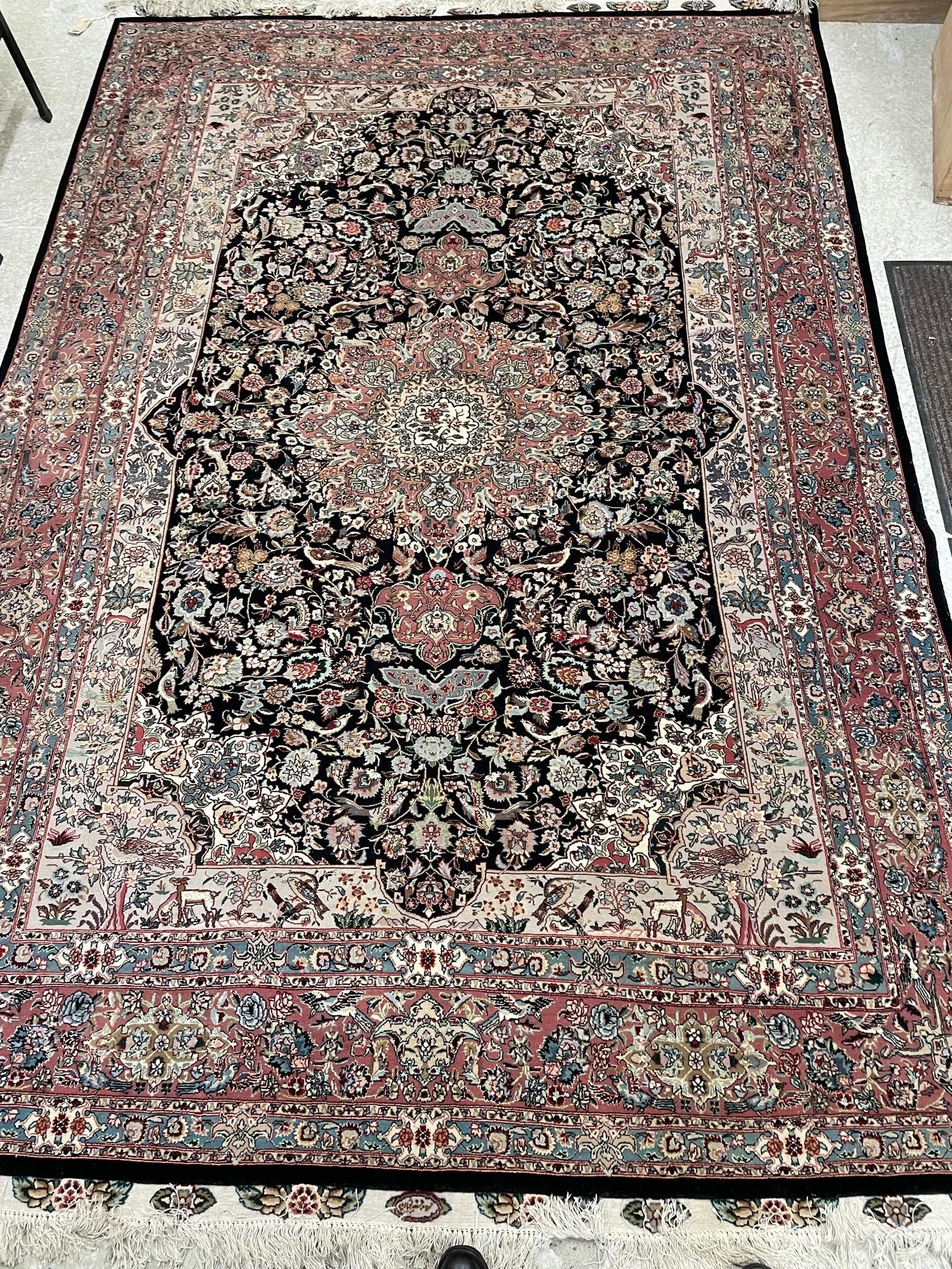 A PERSIAN RUG, the black field with rose pink gul and ivory spandrels within a pale blue border with Image