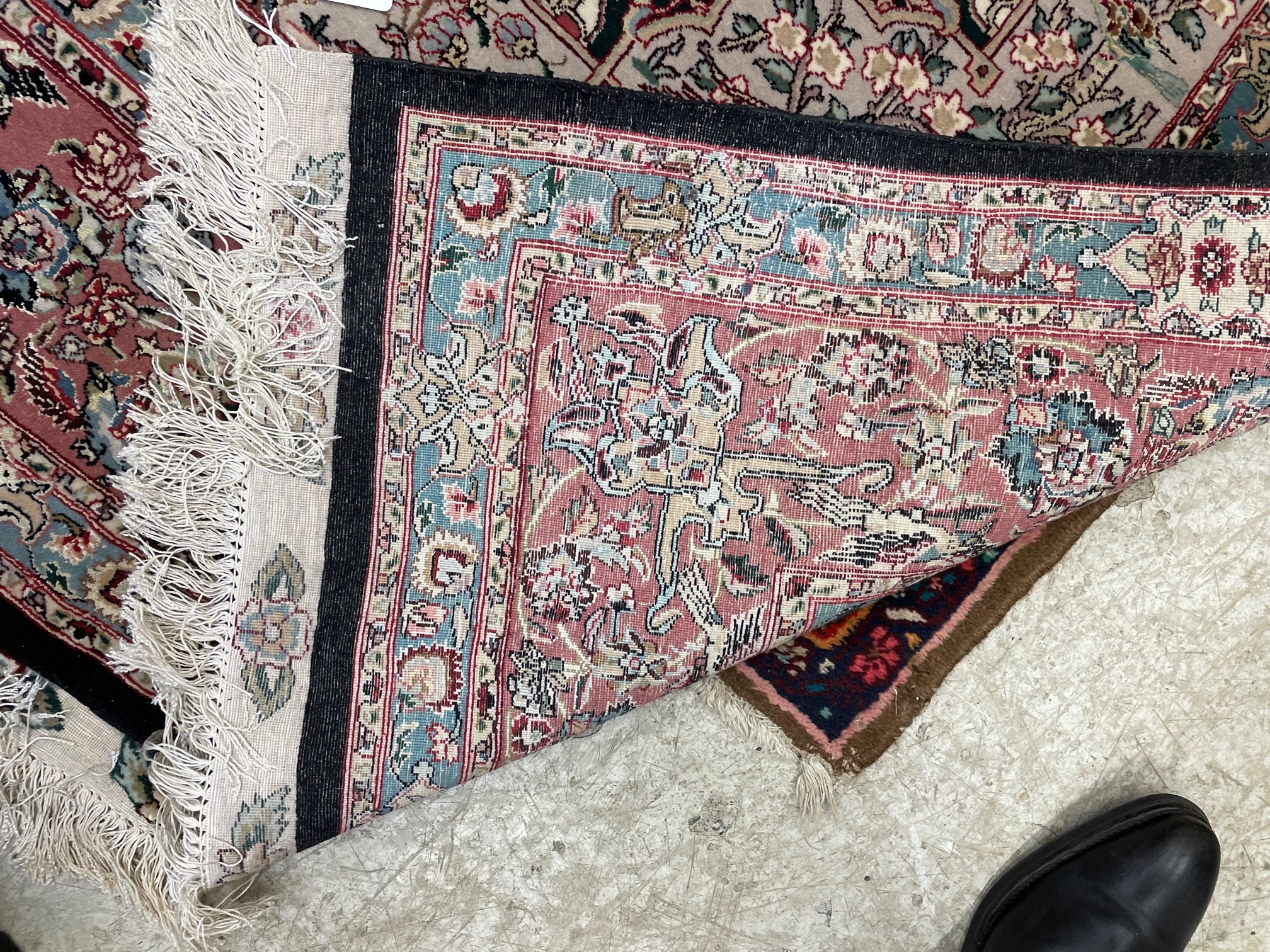 A PERSIAN RUG, the black field with rose pink gul and ivory spandrels within a pale blue border with Image