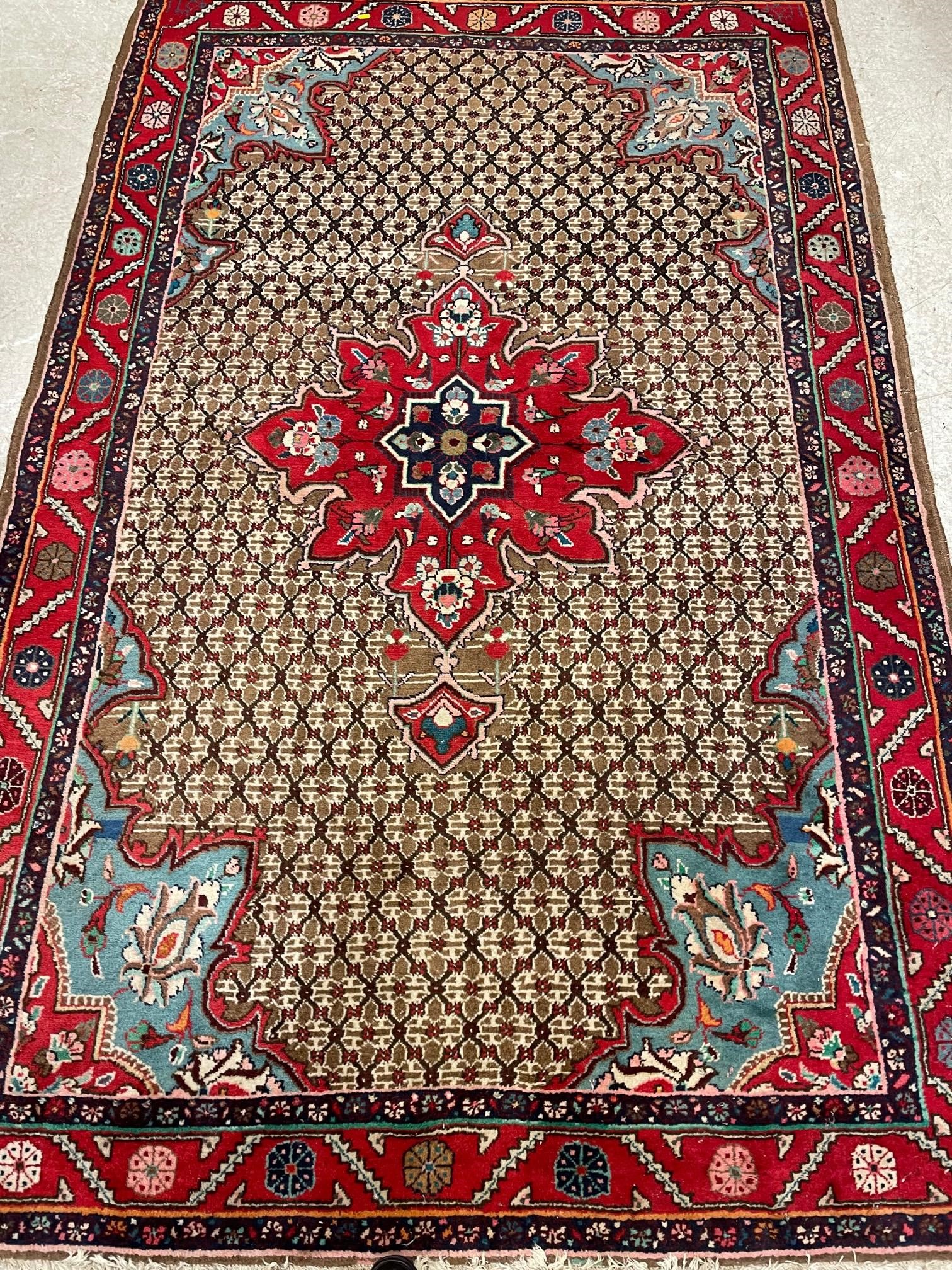 A PERSIAN RUG, the camel trellis patterned field with central crimson gul and pale blue spandrels, Image