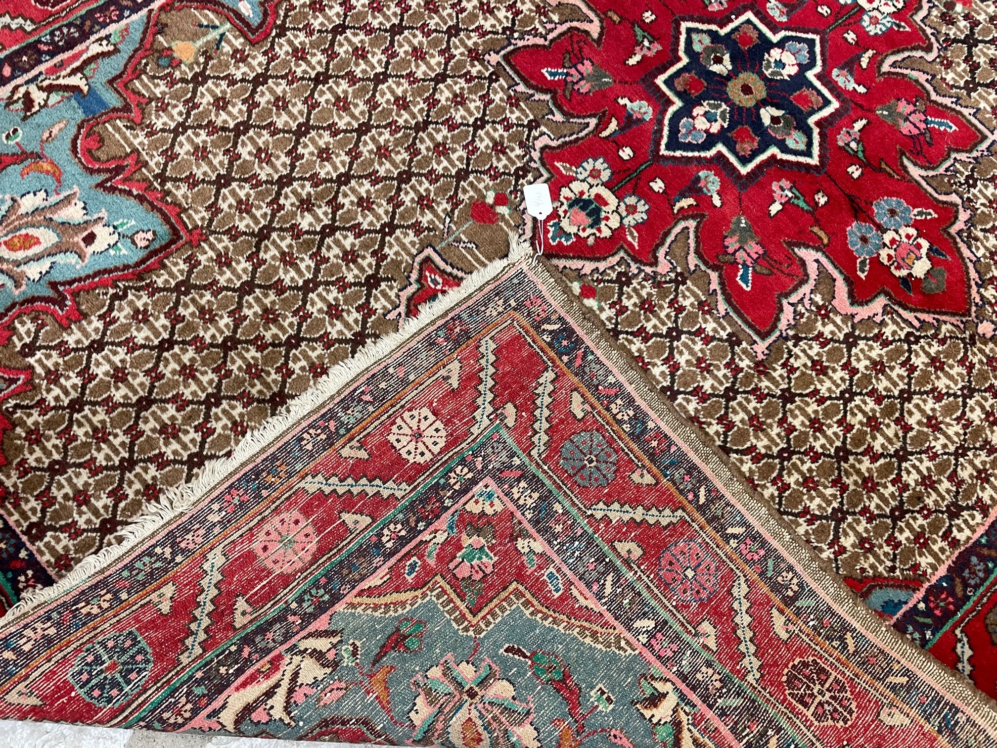 A PERSIAN RUG, the camel trellis patterned field with central crimson gul and pale blue spandrels, Image
