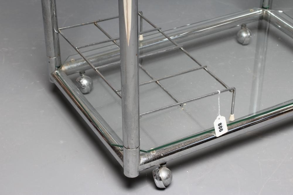 AN ART DECO CHROME TROLLEY of oblong two tier form with glass shelves, chrome bottle housing and Image