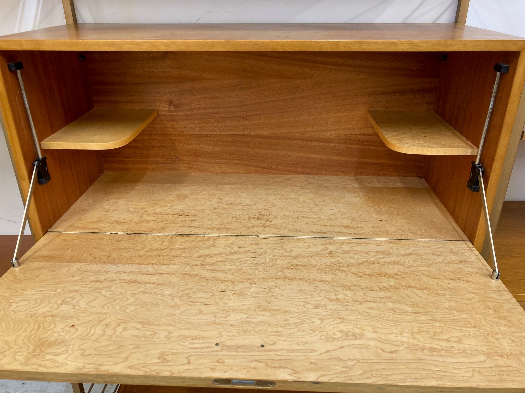 A TEAK STAPLES LADDERAX SECTIONAL MODULAR WALL UNIT in four sections raised on bronzed metal ladders Image