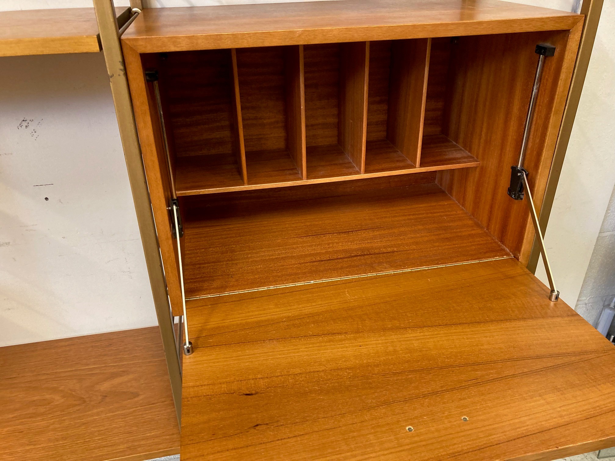 A TEAK STAPLES LADDERAX SECTIONAL MODULAR WALL UNIT in four sections raised on bronzed metal ladders Image