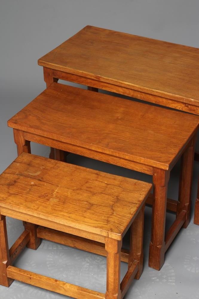 A WILFRED HUTCHINSON (HUSTWAITE) NEST OF THREE ADZED OAK TABLES Image