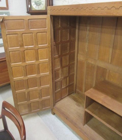 A ROBERT THOMPSON ADZED OAK WARDROBE of oblong multi panelled form with half penny moulded cornice Image