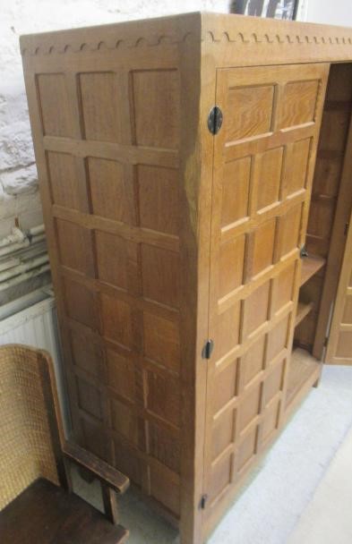 A ROBERT THOMPSON ADZED OAK WARDROBE of oblong multi panelled form with half penny moulded cornice Image