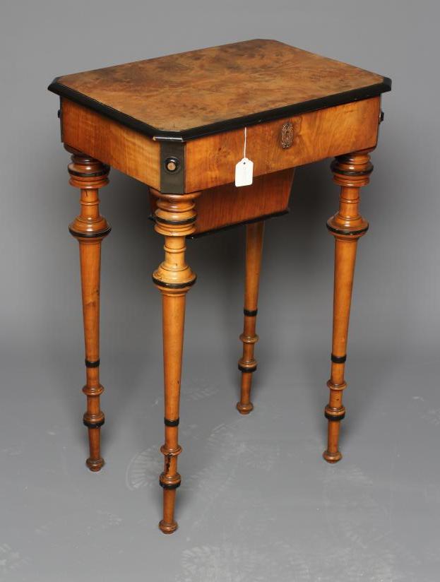 A VICTORIAN WALNUT AND MAPLE SEWING TABLE of canted oblong form with ebony trim Image