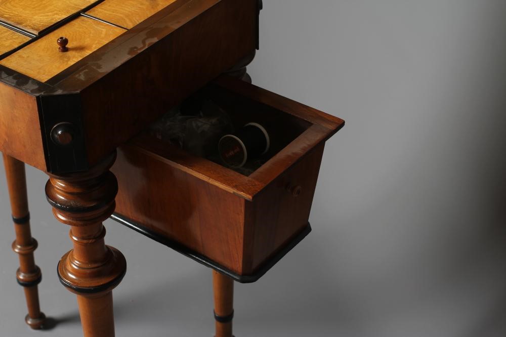 A VICTORIAN WALNUT AND MAPLE SEWING TABLE of canted oblong form with ebony trim Image