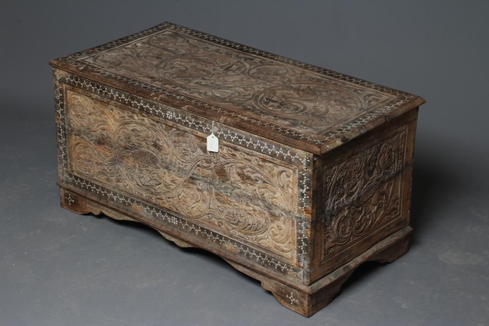 AN INDIAN CARVED WOOD CHEST of oblong form with panels of birds amongst foliate scrolls and with Image