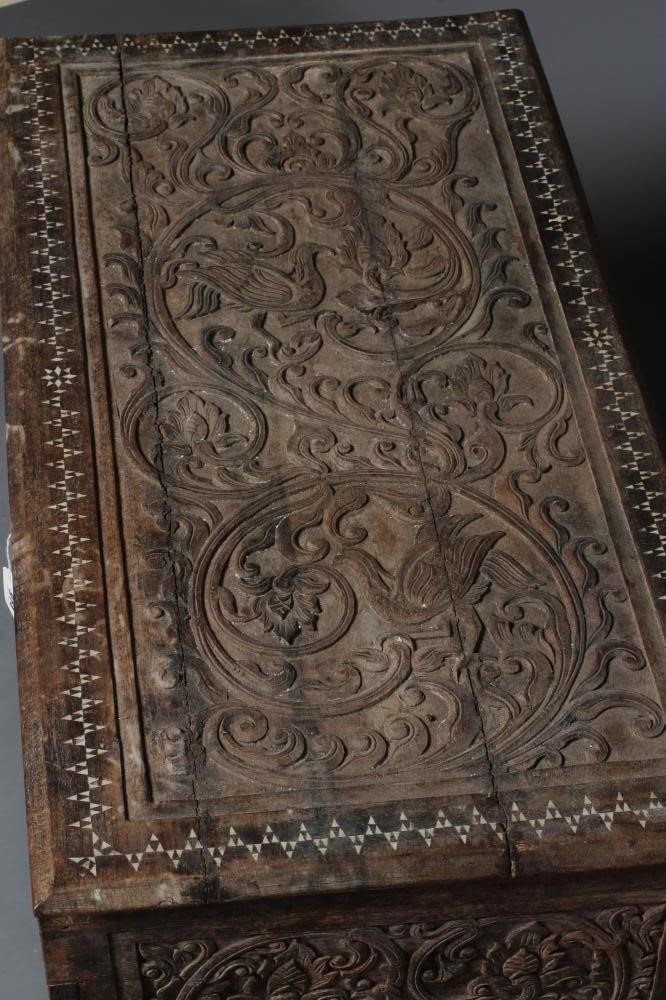 AN INDIAN CARVED WOOD CHEST of oblong form with panels of birds amongst foliate scrolls and with Image