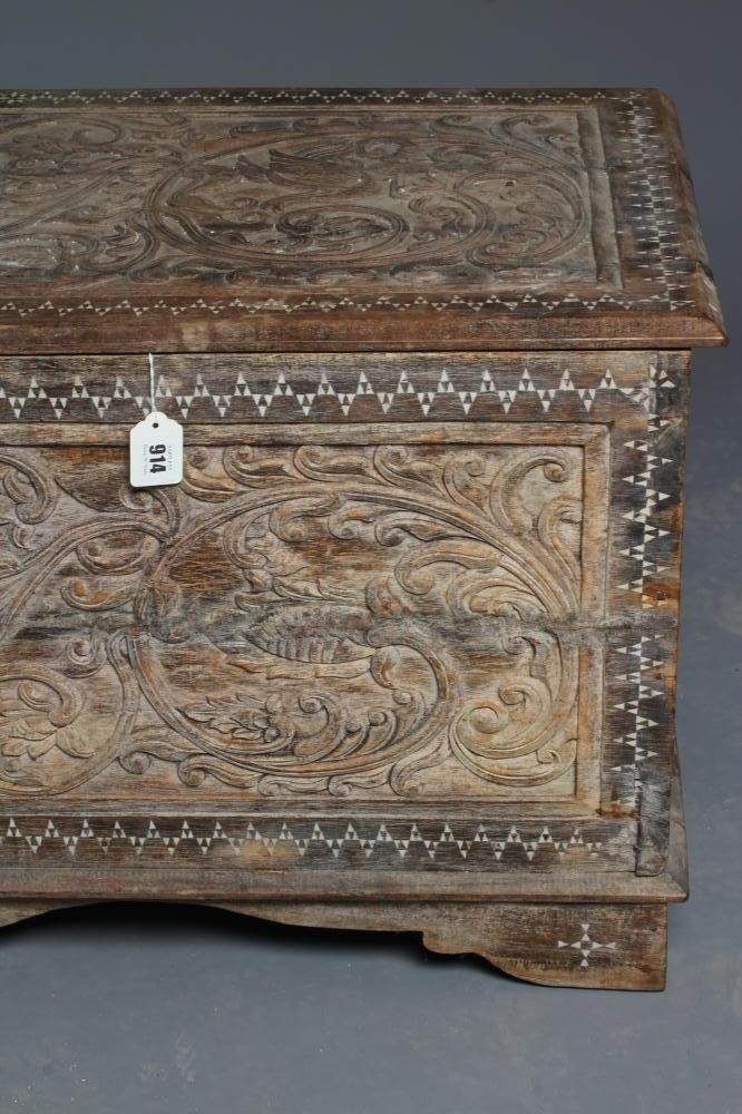 AN INDIAN CARVED WOOD CHEST of oblong form with panels of birds amongst foliate scrolls and with Image