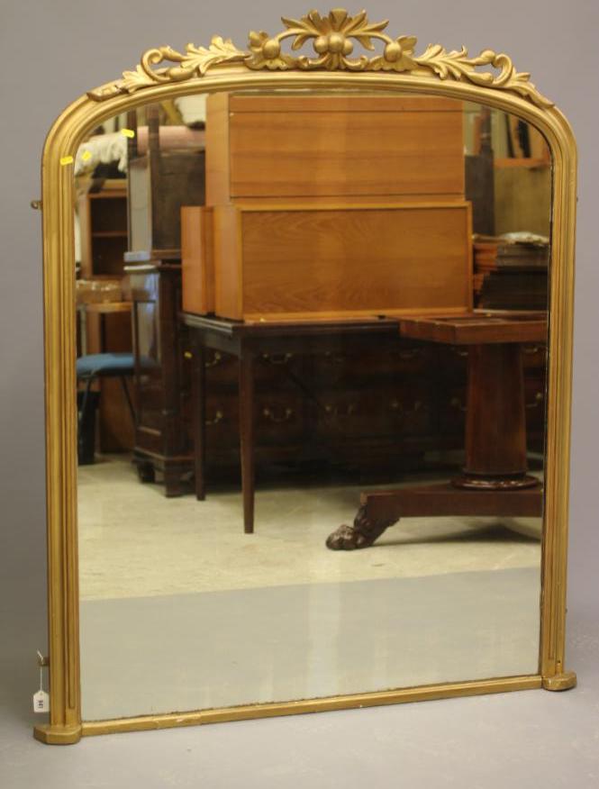 A VICTORIAN GILT WOOD PIER GLASS, the arched plate within a moulded frame with pierced and carved Image