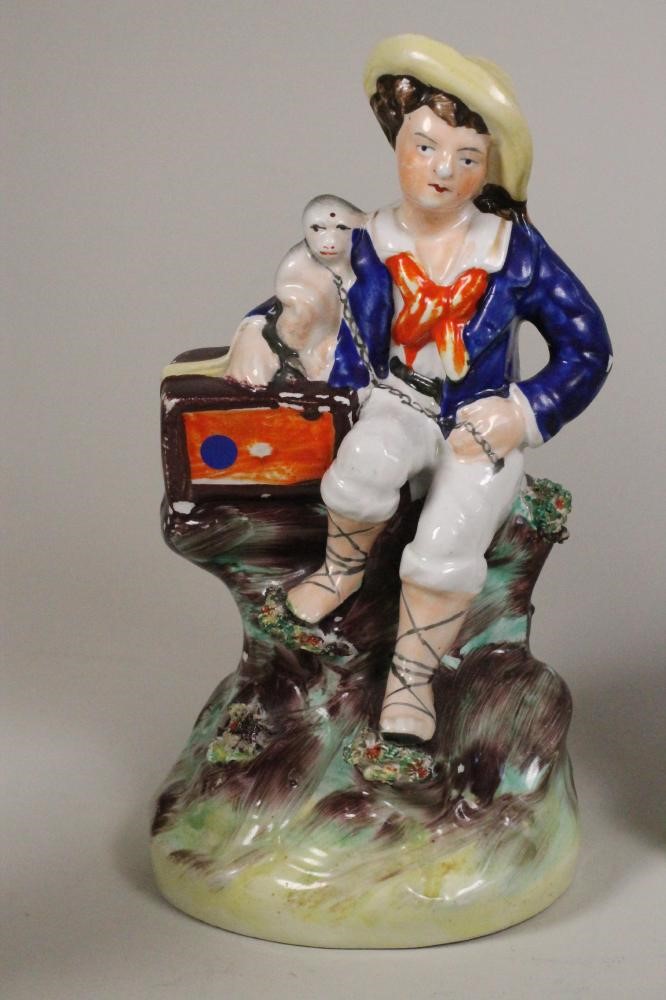 A VICTORIAN STAFFORDSHIRE POTTERY FIGURE of a young boy seated with his arm around a monkey on a Image