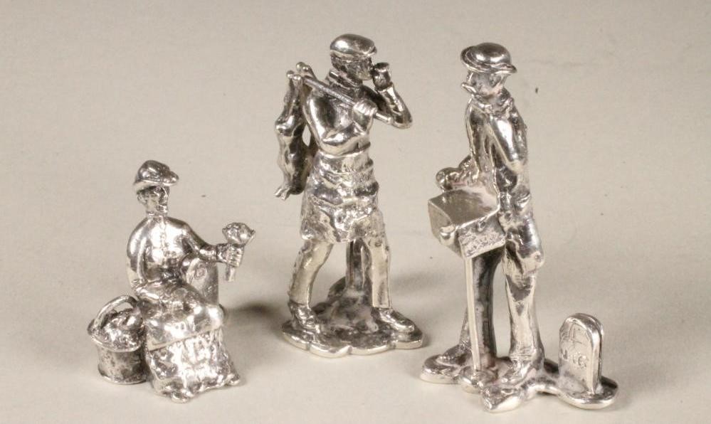 A SET OF NINE NOVELTY SILVER MENU HOLDERS Image