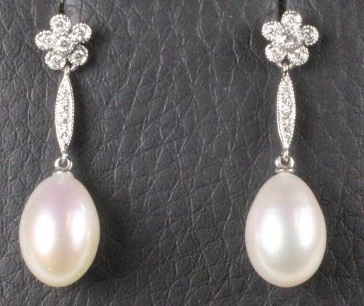 A PAIR OF DIAMOND AND PEARL DROP EAR STUDS Image