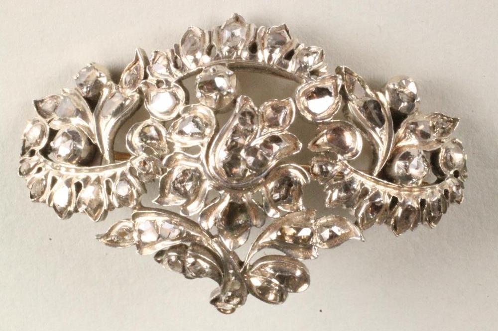 A 19TH CENTURY DIAMOND BROOCH/PENDANT of open convex quatrefoil form centred by a bell flower Image