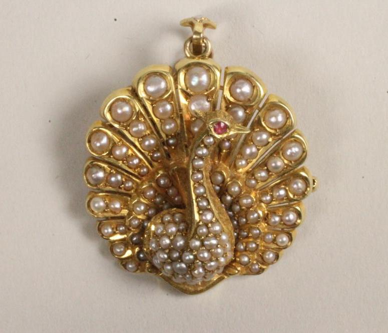 AN 18KT GOLD AND SEED PEARL BROOCH/PENDANT modelled as a peacock with tail fanned Image
