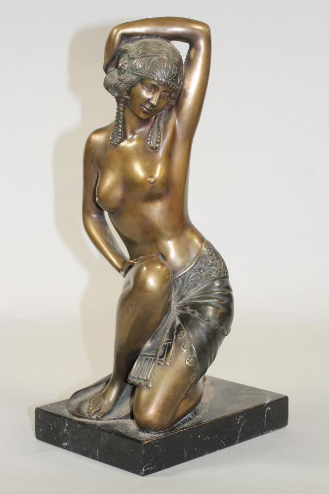AN ART DECO BRONZED FIGURE of a semi naked young woman wearing an Egyptianesque head-dress in her Image