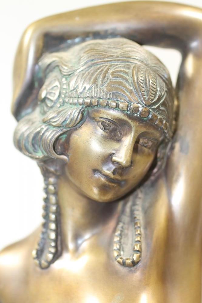 AN ART DECO BRONZED FIGURE of a semi naked young woman wearing an Egyptianesque head-dress in her Image