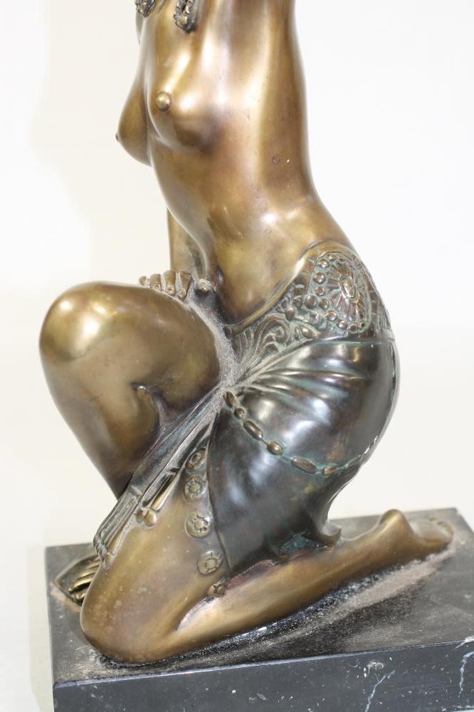 AN ART DECO BRONZED FIGURE of a semi naked young woman wearing an Egyptianesque head-dress in her Image