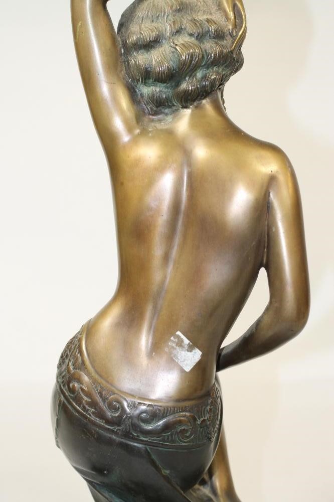 AN ART DECO BRONZED FIGURE of a semi naked young woman wearing an Egyptianesque head-dress in her Image