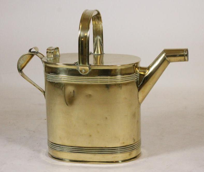 A VICTORIAN BRASS WATERING CAN of oval form with ribbed banding Image