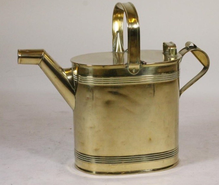 A VICTORIAN BRASS WATERING CAN of oval form with ribbed banding Image