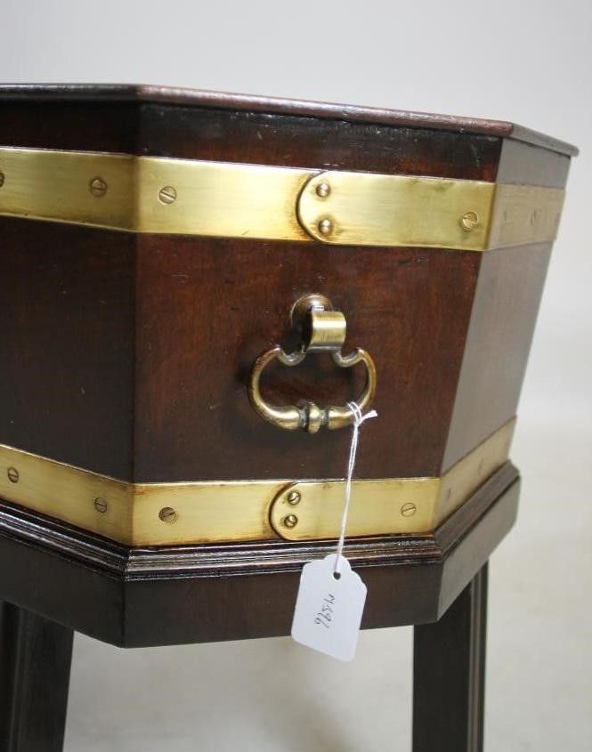 A GEORGIAN DESIGN MAHOGANY AND BRASS BOUND CELLARETTE of canted oblong form with brass loop handles Image