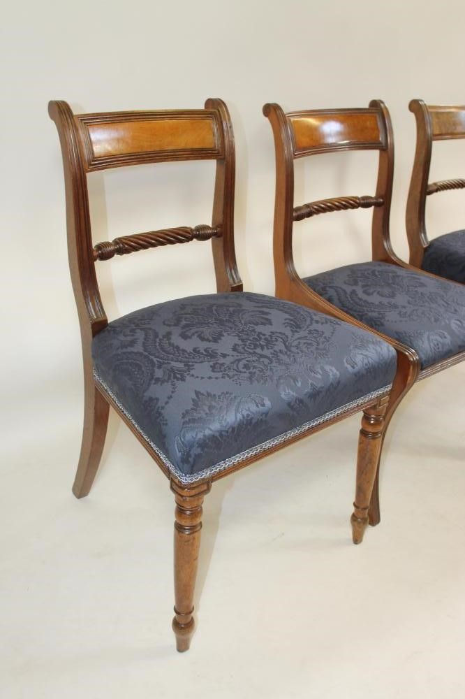 A COMPOSITE SET OF TWELVE REGENCY MAHOGANY DINING CHAIRS covered in deep blue damask and comprising Image