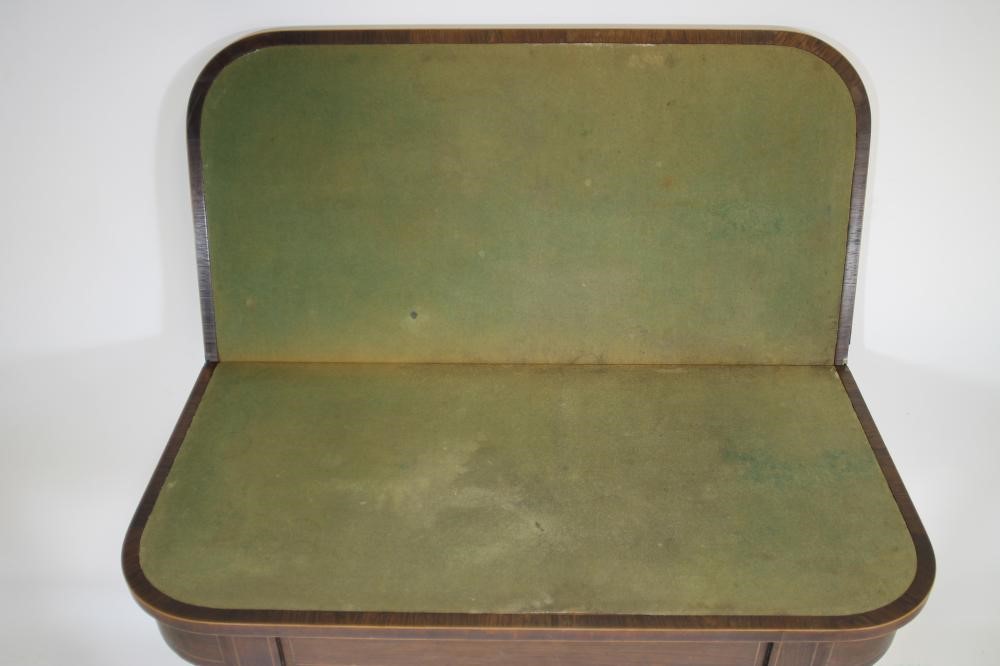 A REGENCY ROSEWOOD FOLDING CARD TABLE of rounded oblong form crossbanded with stringing Image