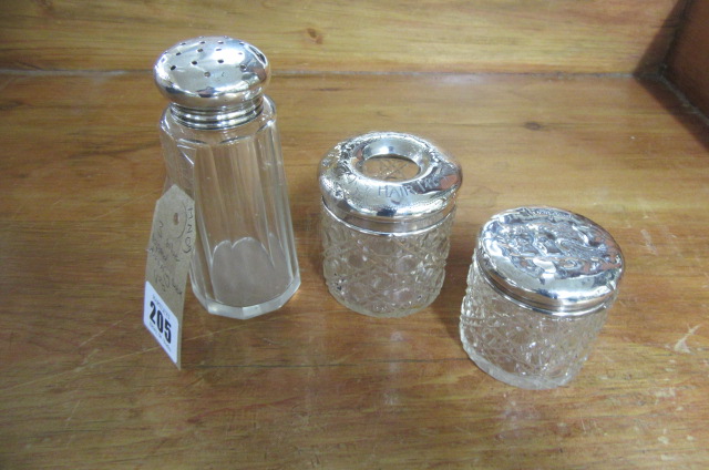 THREE SILVER TOPPED DRESSING TABLE JARS AND A CASTOR Image