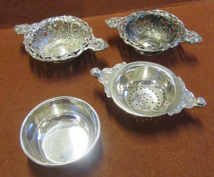 PAIR OF SILVER EMBOSSED DISHES AND A TEA STRAINER Image
