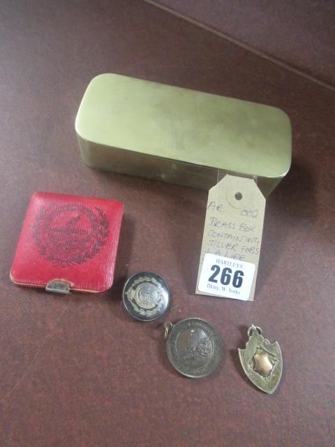 BRASS BOX CONTAINING SILVER FOBS AND A LIFE SAVING MEDAL Image