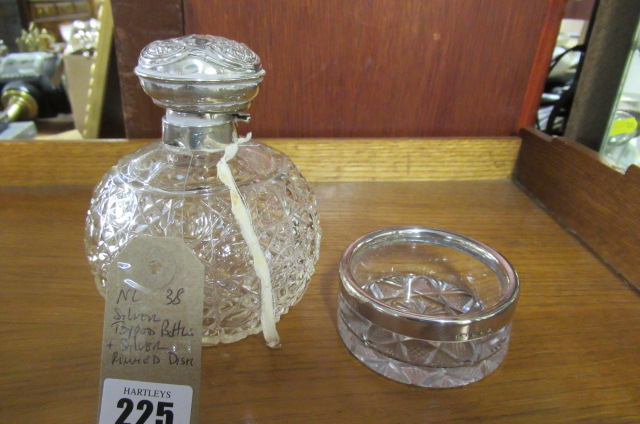 SILVER TOPPED BOTTLE AND A SILVER RIMMED DISH Image
