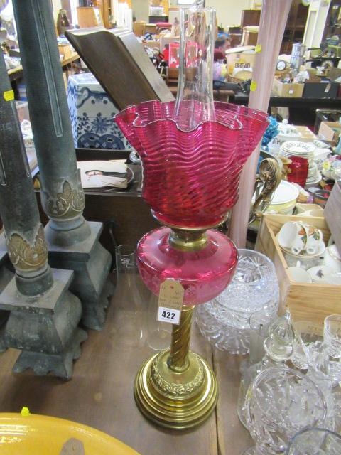 CRANBERRY AND GLASS OIL LAMP AND TWO GLASS CHIMNEYS Image