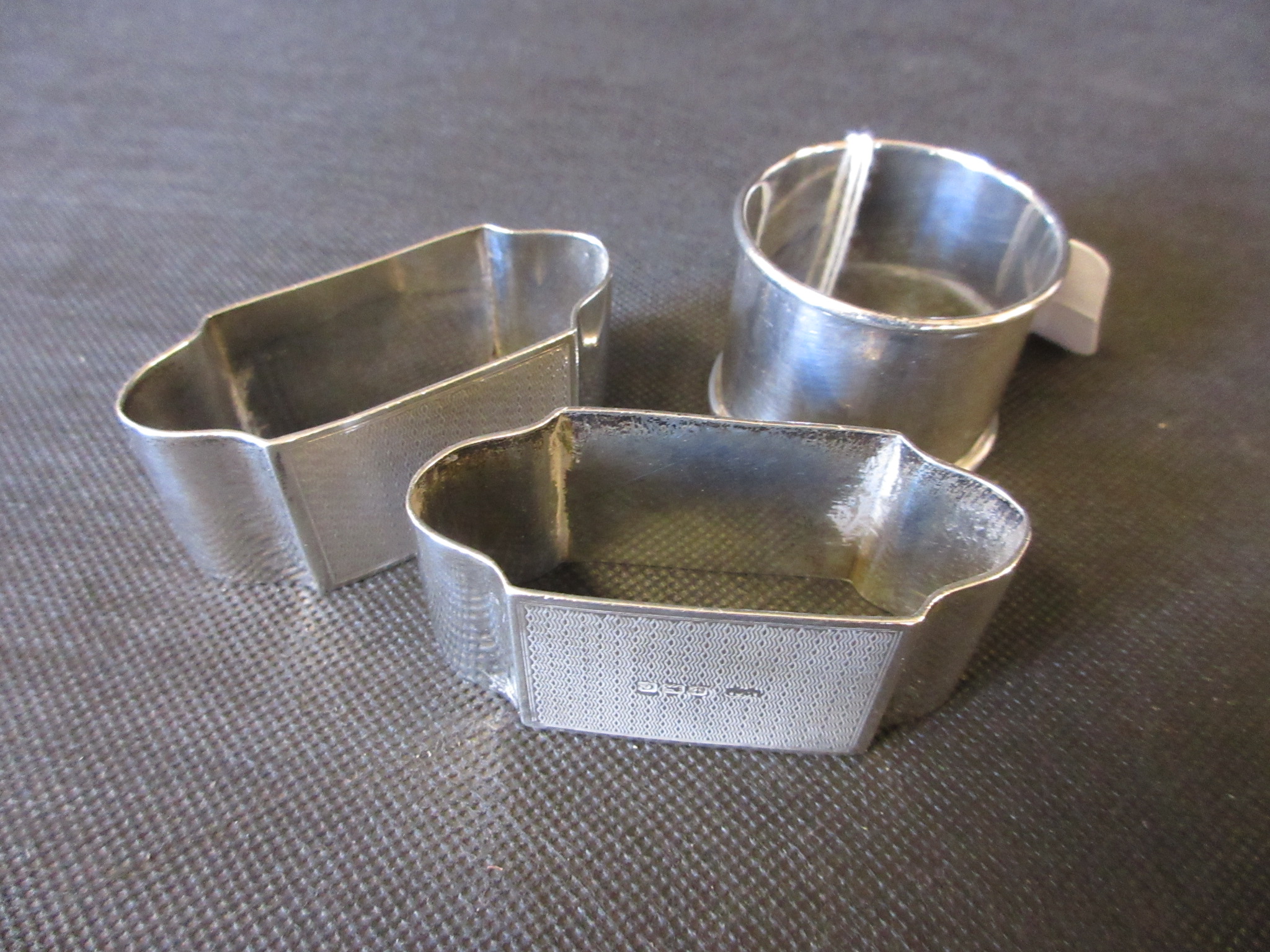 PAIR OF SILVER ENGINE TURNED NAPKIN RINGS AND ANOTHER Image