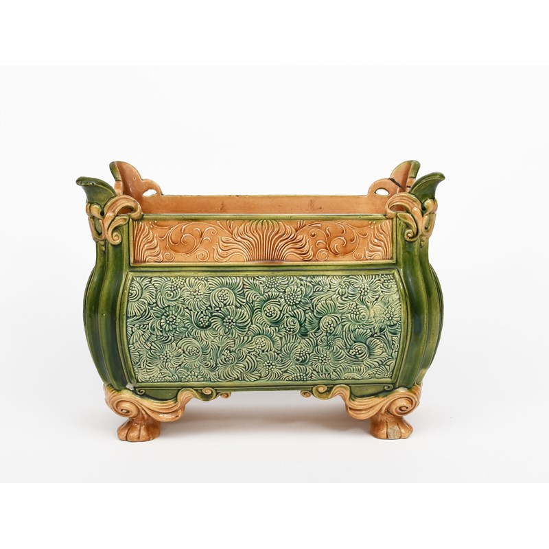 A doulton lambeth majolica ware planter, rectangular on four scroll