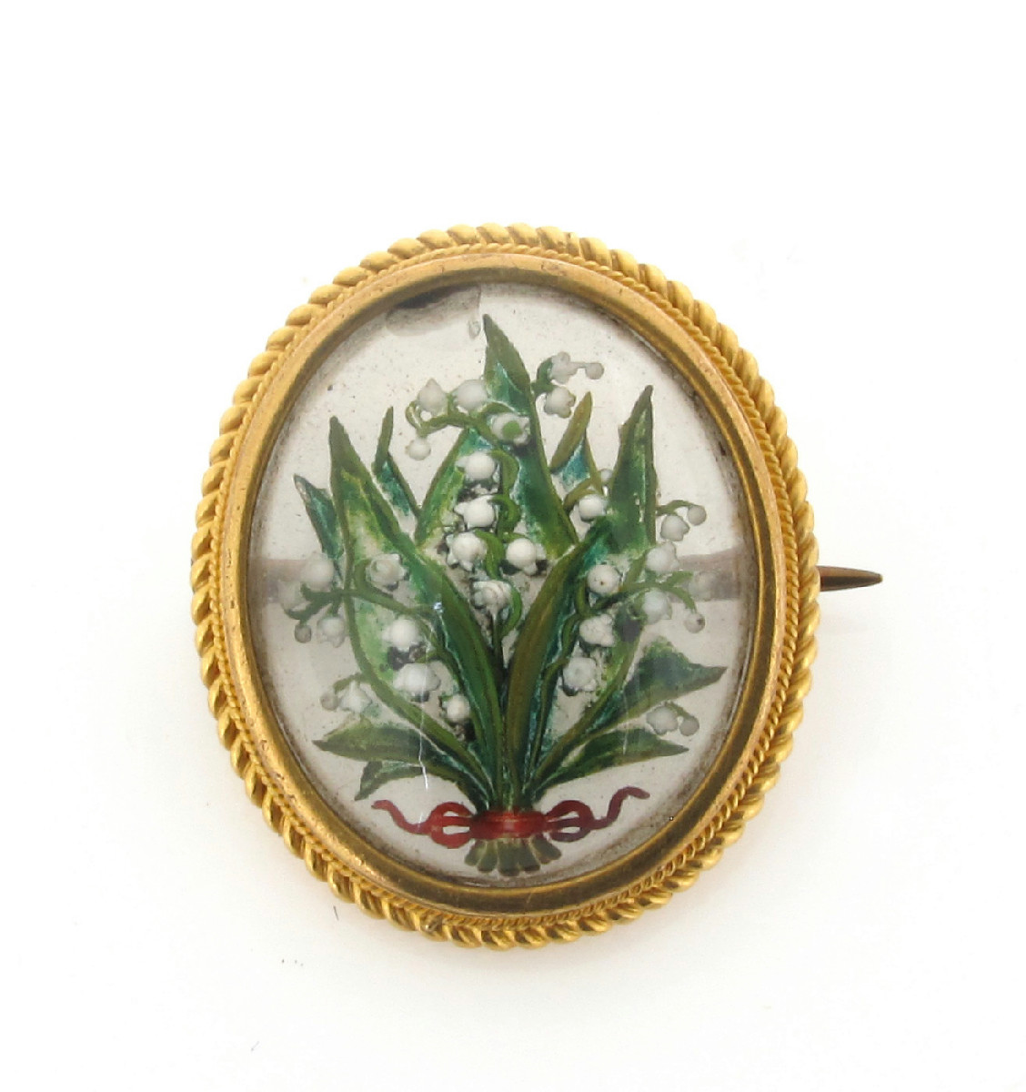 A reverse painted carved crystal brooch, depicting lily of the valley ...