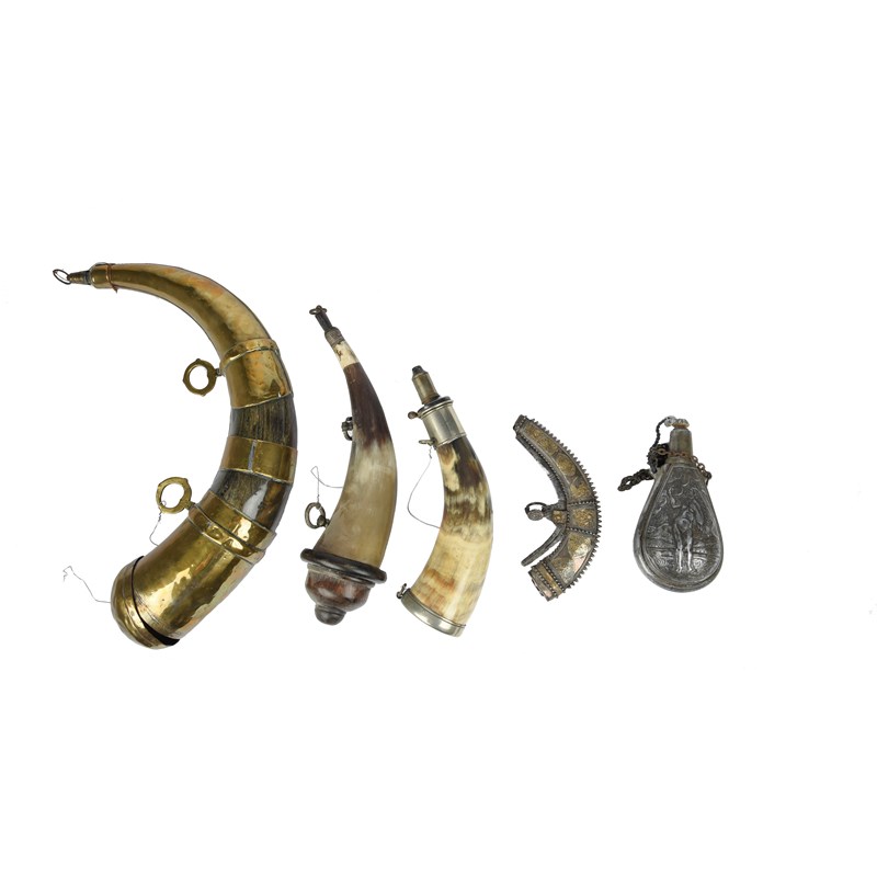 A small collection of powder flasks, comprising: an omani silver flask ...