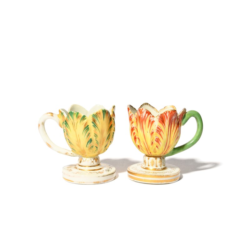 A pair of derby tulip cups, c.1815, on circular feet, each modelled as ...